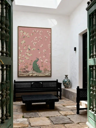 A large scale Chinoiserie peacock mural displayed in a white-walled courtyard with a black carved bench and stone floors.