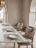 The Kasbah premium woven jute placemat with scalloped cream linen corners styled under gold-rimmed plates on a marble table.
