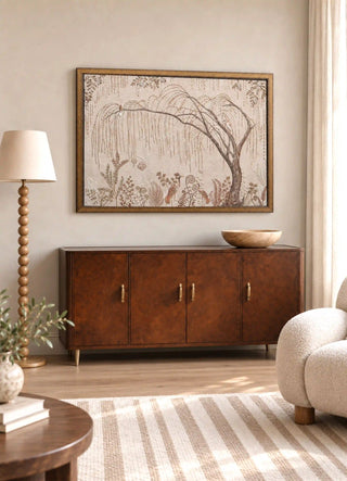 The Secret Garden embroidered wall art framed above a burl-wood sideboard beside a bobbin floor lamp in a living room.