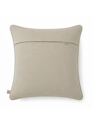 Back view of The Sirocco cushion cover showing the plain sand-toned reverse panel with concealed closure