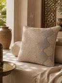 The Sirocco cushion cover with woven jute and velvet diamond detail resting on a sunlit daybed beside a brass tray