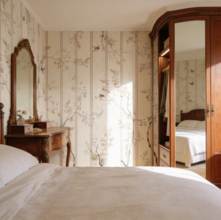 The Syntax of Spring vintage botanical striped wallpaper mural styled as an elegant main accent backdrop behind a cozy warm-toned master bed layout.