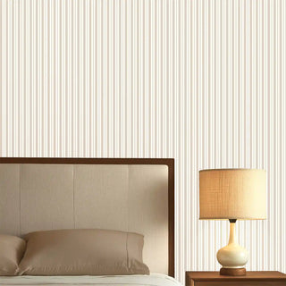 Bedroom wall styled with Thin Stripe Beige & Cream Wallpaper Roll, featuring soft beige and cream vertical thin stripes paired with a modern wooden bed and beige bedding for a calming atmosphere.