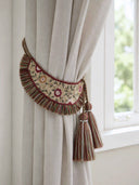 The Thiya luxury embroidered curtain tieback styled symmetrically on a neutral linen curtain frame, bringing a pop of classical color.