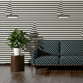 Sofa upholstered in Trang Fabric featuring navy and ivory design against striped wall.