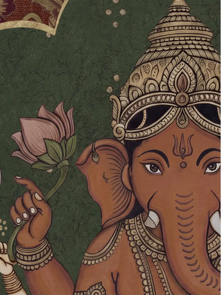 A detailed view of the Trideva Mangalam wall art showing Ganesha’s face, jewelled crown and a lotus held in one hand against a crackled green ground.