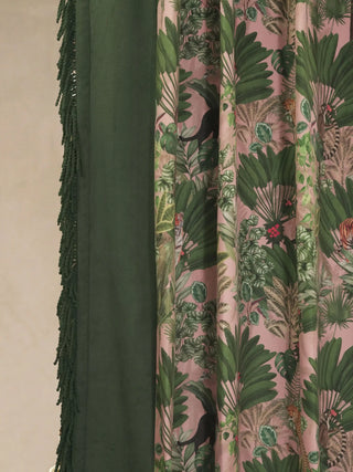 Detailed view of the deep green velvet border and hand-knotted wool fringe on the edge of the Tropical Tales curtain.