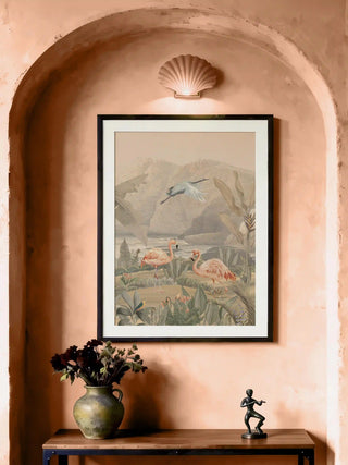Tropical Vintage flamingo print styled in a carved gold frame above a dark wood console table with a peacock figure.