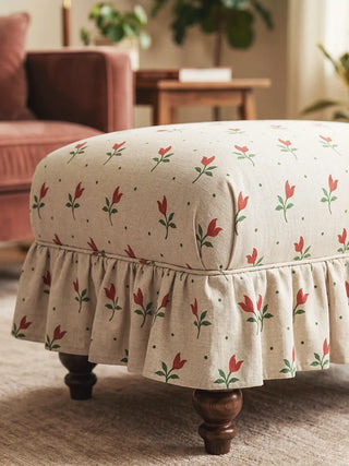 A detailed view of a ruffled vanity stool upholstered in the Tulip Field floral pattern.