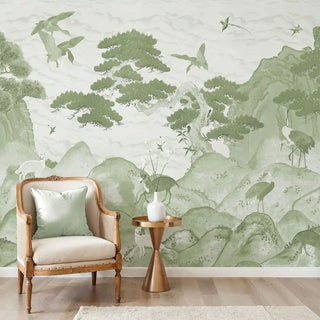 The Vana Geet sage green mural styled in a luxury living room behind a classic armchair and gold side table.