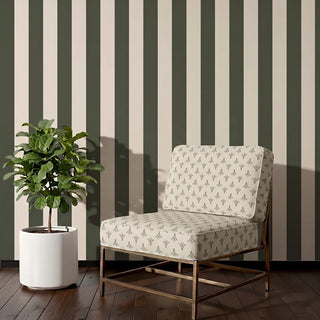 Vanya upholstery fabric in olive ivory on a brass-framed accent chair beside a fiddle leaf fig, against olive striped walls in a living room corner.