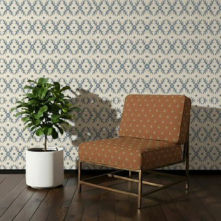 Vasant Sofa and Chair Upholstery Fabric in earthy terracotta with embroidered floral motifs, styled on a chair.