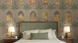A serene bedroom decorated with a Vastu-compliant wallpaper displaying intricate traditional patterns and arched windows in muted greens and earthy colors, behind a bed with a green upholstered headboard.