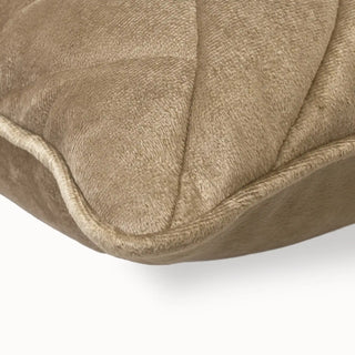 Close-up of the light beige cushion corner showing the geometric quilting and piping.