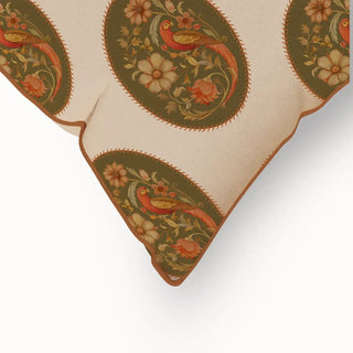 A close-up of the "Vintage Blossom Pipin" cushion cover's corner, highlighting the piped edge and the intricate details of the vintage bird and floral motifs within the oval patterns.