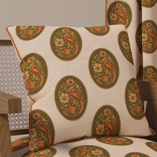 The "Vintage Blossom Pipin" cushion cover displayed on a chair, showcasing its elegant and classic style in a cozy, warm setting.