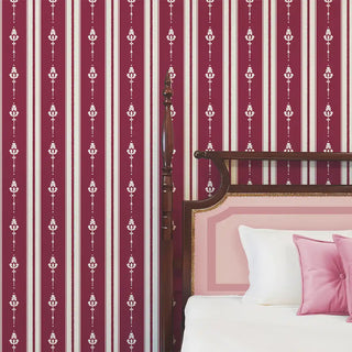 Bedroom wall styled with Vintage Maroon & Beige Motif Stripe Wallpaper Roll, featuring bold maroon stripes with beige floral motifs, paired with a wooden bed and pink accent cushions.