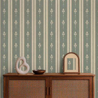 Vintage Olive & Beige Motif Stripe Wallpaper Roll covering a living room wall, paired with a cane cabinet, mirror, and decorative accents for a warm traditional setting.