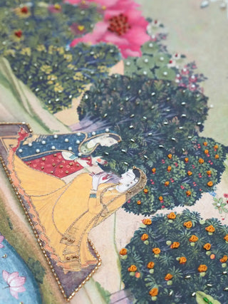 A close-up of the Vrindavan mural showing hand-embroidered figures with pearl accents and 3D floral beadwork.