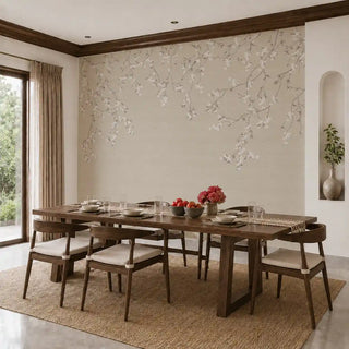 The Whispering Branches wallpaper mural in Sepia installed on a feature wall in a dining room behind a wooden dining table set for a meal. view-dining