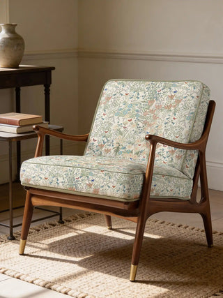 A mid-century modern wooden armchair upholstered in Whispers of Spring wildflower fabric.