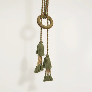 Close-up shot of the Woodland Essence Tassel hanging, detailing the woven ring and the green tassels accented with natural wood beads.