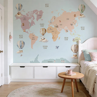 A sophisticated kids' bedroom featuring the blue world map mural above a white storage unit with a wooden side table.