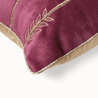Close-up of the maroon velvet cushion corner showing the gold bead and leaf embroidery.