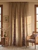 The Zarqash hand-embroidered luxury gold-beige velvet curtains styled inside an elegant traditional sitting room next to a carved wooden chair.