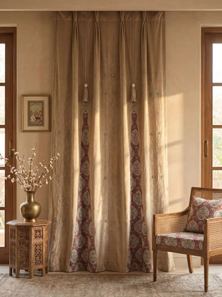 The Zarqash hand-embroidered luxury gold-beige velvet curtains styled inside an elegant traditional sitting room next to a carved wooden chair.
