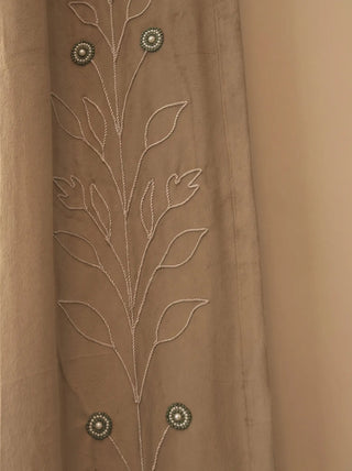 A high-resolution close-up detail of the Zarqash velvet curtain panel showing its hand-stitched zardozi leaf cording and green pearl medallions.