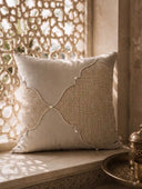 Zayan Weave cushion cover with jute quatrefoil detail resting on a marble window seat beside a carved wooden screen