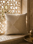The Zayan Weave suede and jute cushion cover styled beautifully in a sunlit stone window alcove with carved Moroccan stone screens.