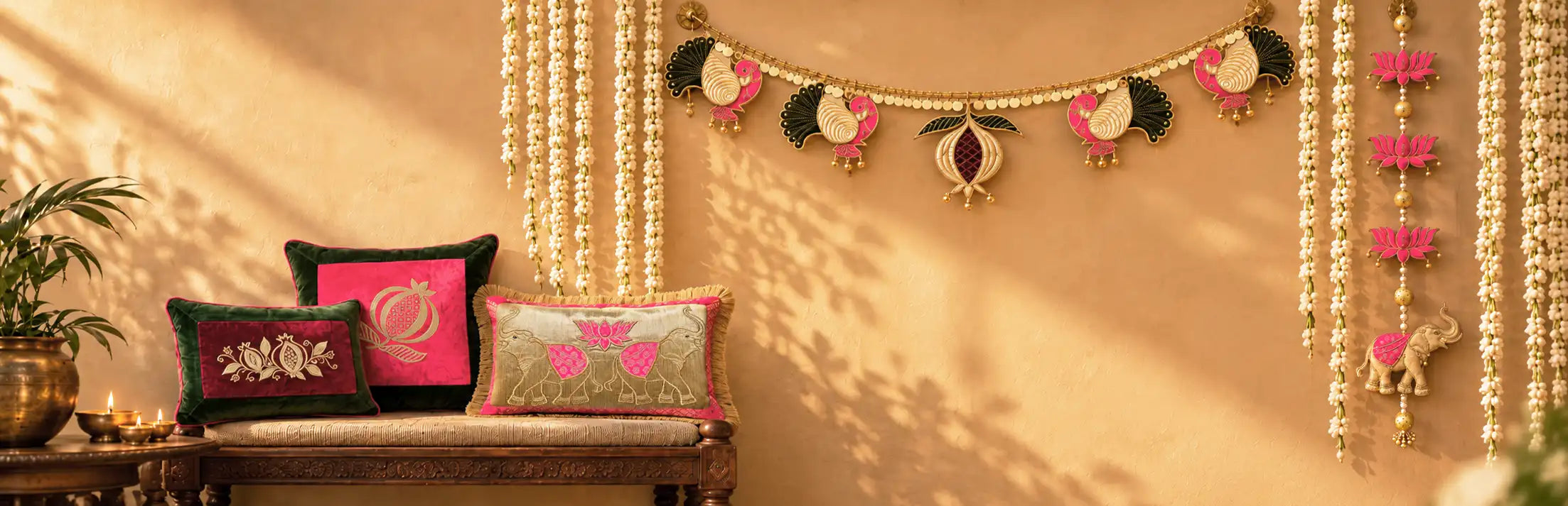 Festive wall with a peacock bandhanwar toran, lotus and elephant door hangings, jasmine garlands and embroidered silk cushions on a carved wooden bench